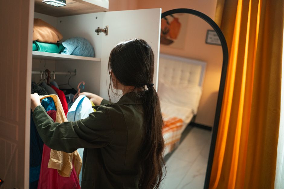 Woman organizing clothes in a bright custom closet